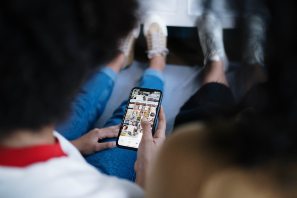 Pessoas em rede social pelo celular, representando o serviço de conteúdo para geração de demanda B2B da A Estranhamente