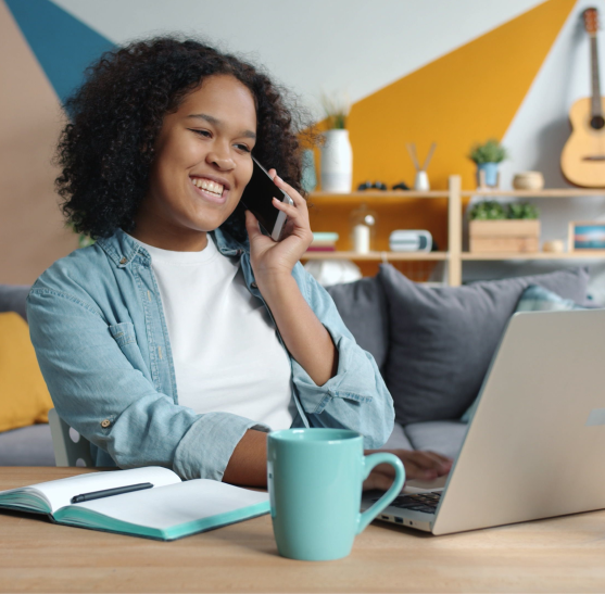 Profissional sorrindo ao telefone com notebook e caderno, representando a Mentoria Conecta & Converte da A Estranhamente